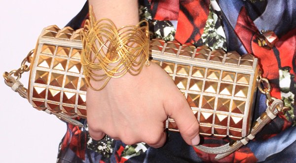 Amanda Seyfried accessorizes her bold Peter Pilotto dress with a gold-studded Jimmy Choo Cosma clutch and a striking gold wire bracelet