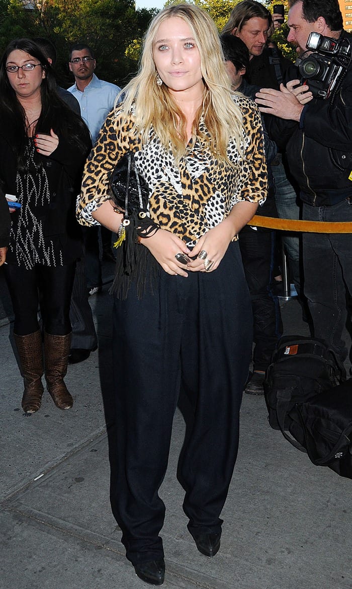 Mary-Kate Olsen steps out in New York wearing a leopard-print button-down shirt with rolled-up cuffs, grounding the look with pointed black ankle boots