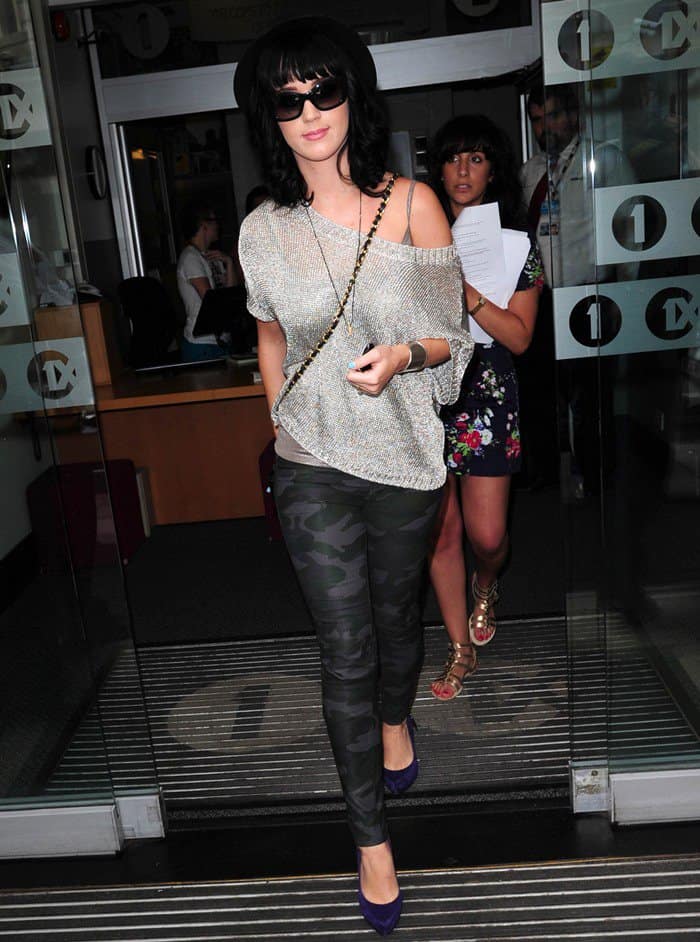 Katy Perry showcased her unique fashion sense in camouflage leggings, a glittery metallic sweater by Vince, and striking purple suede pumps by Rock Republic