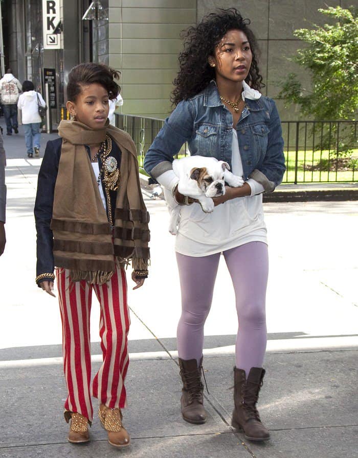 Captured on October 19, 2010, Willow Smith strolls through Manhattan in studded tan ankle boots, pairing them with bold red-and-white striped pants and a stylish camel scarf, effortlessly showcasing her fearless fashion sense