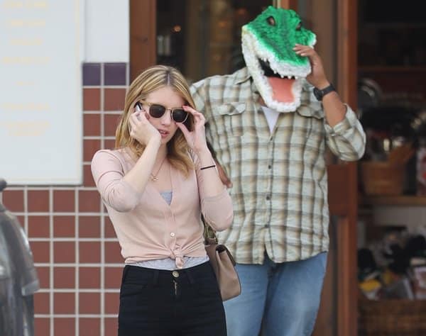 Emma Roberts chats on the phone while running errands in Beverly Hills on October 29, 2010, seemingly unfazed by a man in a crocodile mask behind her