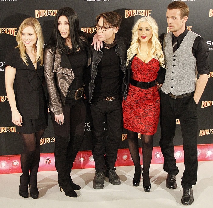 Kristen Bell, Cher, director Steven Antin, Christina Aguilera, and Cam Gigandet pose at the Madrid photocall for Burlesque, each showcasing their own distinctive red carpet style
