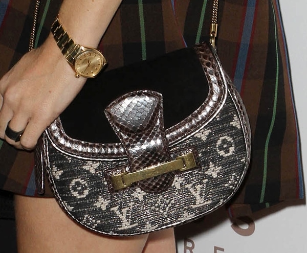 Chloë Sevigny totes a stylish Louis Vuitton handbag with a distinctive combination of patterned fabric and metallic accents