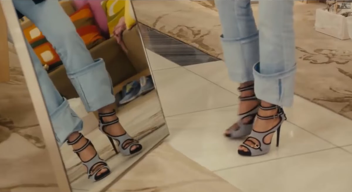 Jennifer Aniston models gray suede Tabitha Simmons Bailee heels, with their high stiletto design, vertical strap placement, and open-toe silhouette creating a flattering elongating effect on her legs