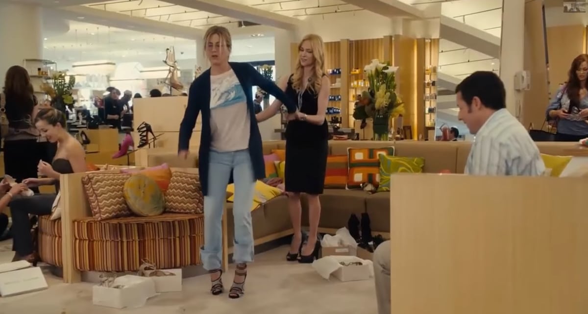 Jennifer Aniston tries on strappy high heels while shopping for designer shoes in a memorable scene from the 2011 romantic comedy Just Go With It