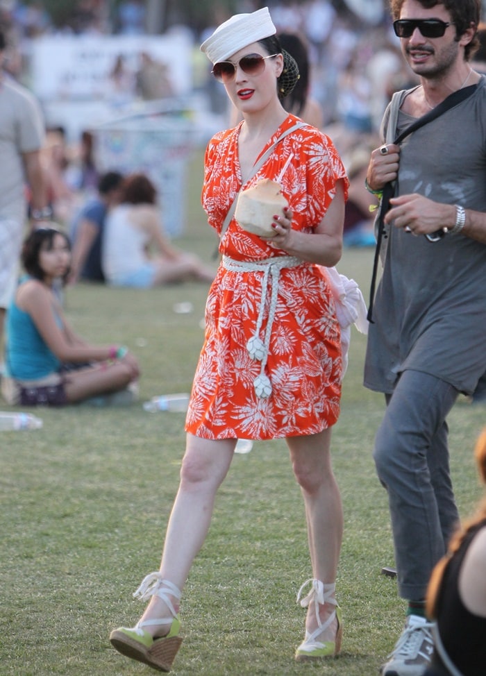 Dita Von Teese channels vintage nautical glamour at Coachella in a bold tropical-print dress, rope belt, sailor hat, and lace-up espadrille wedges—effortless retro festival chic