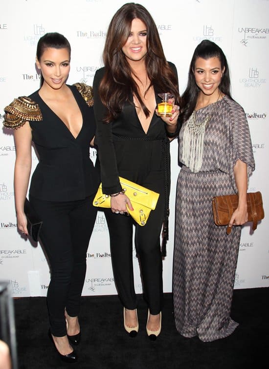 Kim Kardashian stuns in a structured black blazer with gold-embellished shoulders and classic black pumps, while Khloé Kardashian turns heads in a plunging black jumpsuit paired with chic two-tone cap-toe pumps, and Kourtney Kardashian keeps it boho-chic in a printed maxi dress with a brown clutch and neutral heels at the launch of "Unbreakable" on April 4, 2011, in Hollywood, California