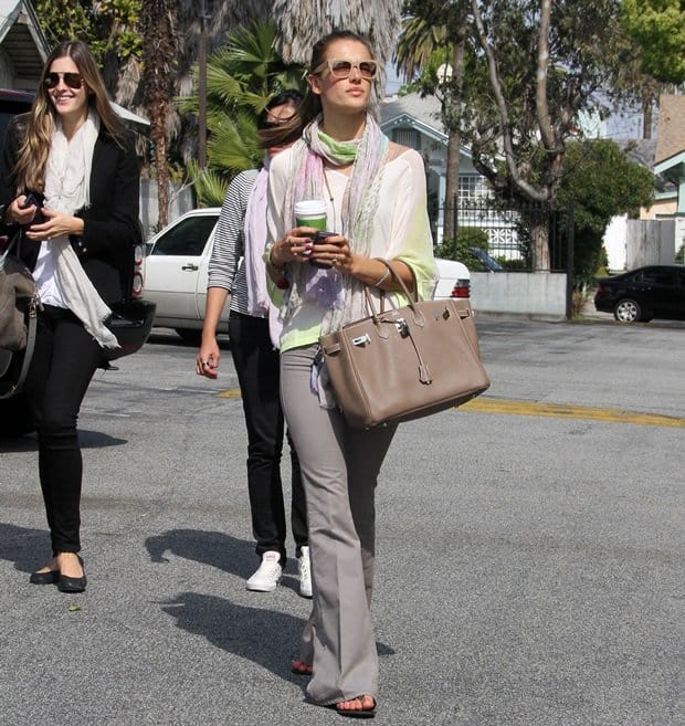 Alessandra Ambrosio in Los Angeles on April 13, 2011, pairing a Gypsy 05 Orian silk top with Rag Bone bell jeans, flat sandals, and a 35cm Hermès Birkin in Etoupe with Palladium hardware for an off-duty look grounded in ease and balance