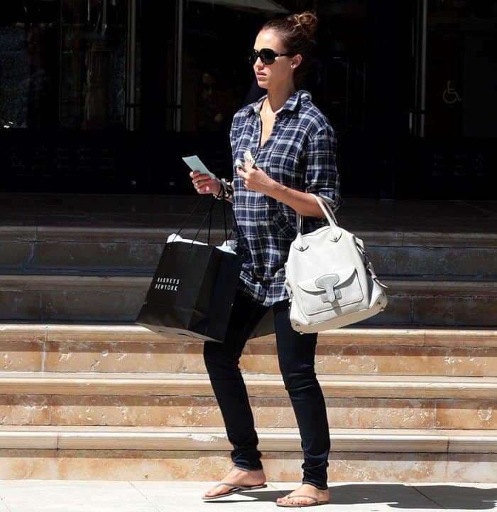 Jessica Alba kept her off-duty maternity style relaxed in a plaid Rails “Jaclyn” tunic, J Brand Maria high-rise leggings, and smoke-colored Trove Tkees flip-flops, finishing the look with oversized Versace sunglasses and her ivory Loewe “May” bag