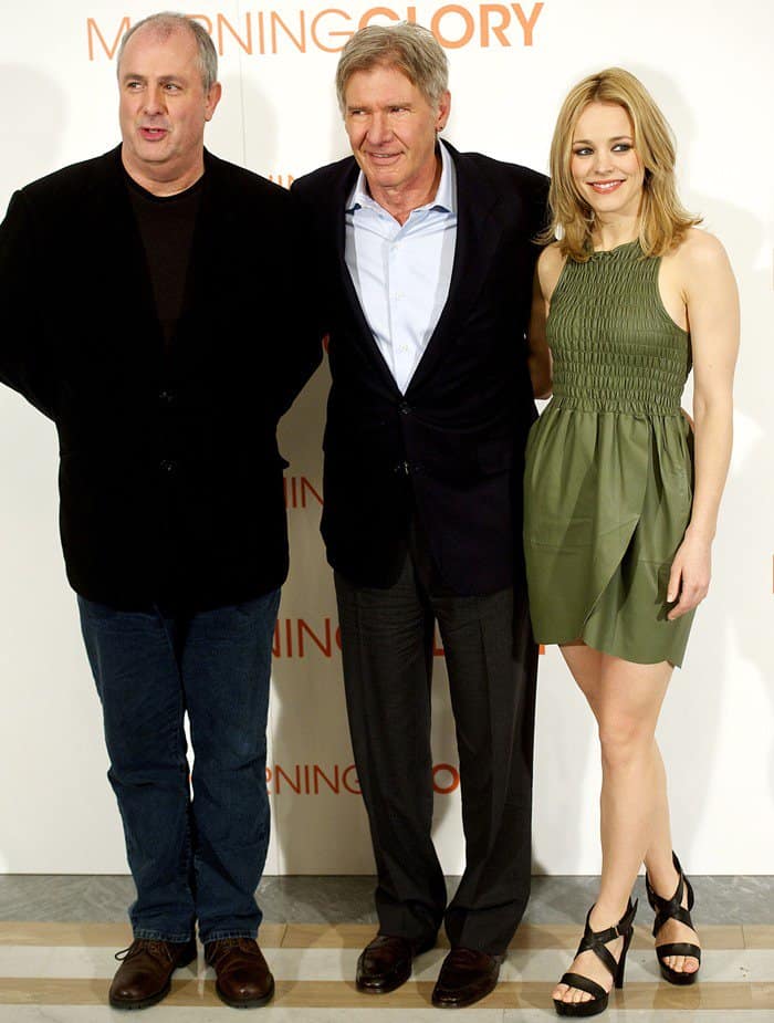 Rachel McAdams poses with director Roger Michell and co-star Harrison Ford at the Morning Glory photocall in Madrid, showcasing her olive Geren Ford dress and black Michael Kors platform heels