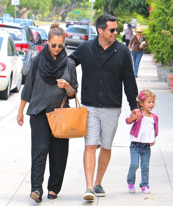 Jessica Alba keeps her maternity style chic in loose black separates, Jil Sander flats, and a camel Valentino Rockstud tote while enjoying a family lunch in Brentwood with husband Cash Warren and daughter Honor on May 29, 2011