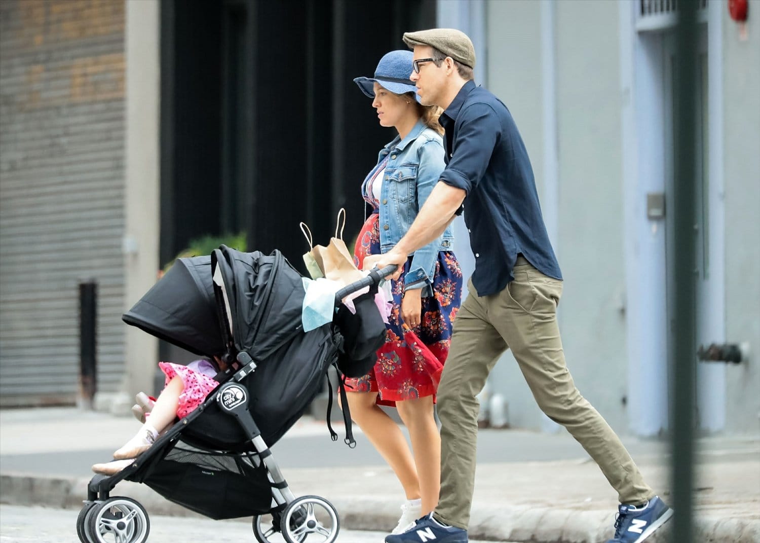 Blake Lively keeps it casual in a floral dress, denim jacket, and sneakers while Ryan Reynolds pairs a navy shirt with khaki pants and New Balance sneakers as they enjoy a family stroll with their daughters