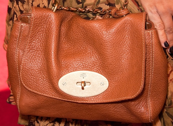 Camilla Belle pairs her autumnal ensemble with a classic tan Mulberry leather shoulder bag featuring the brand’s signature postman’s lock