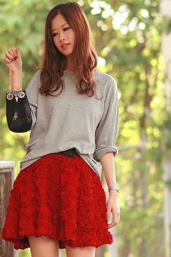 Mayo Wo of Mellow Mayoness Mayo Wo embraces her signature feminine style in a textured red rosette skirt paired with a casual gray top and chic owl-shaped bag