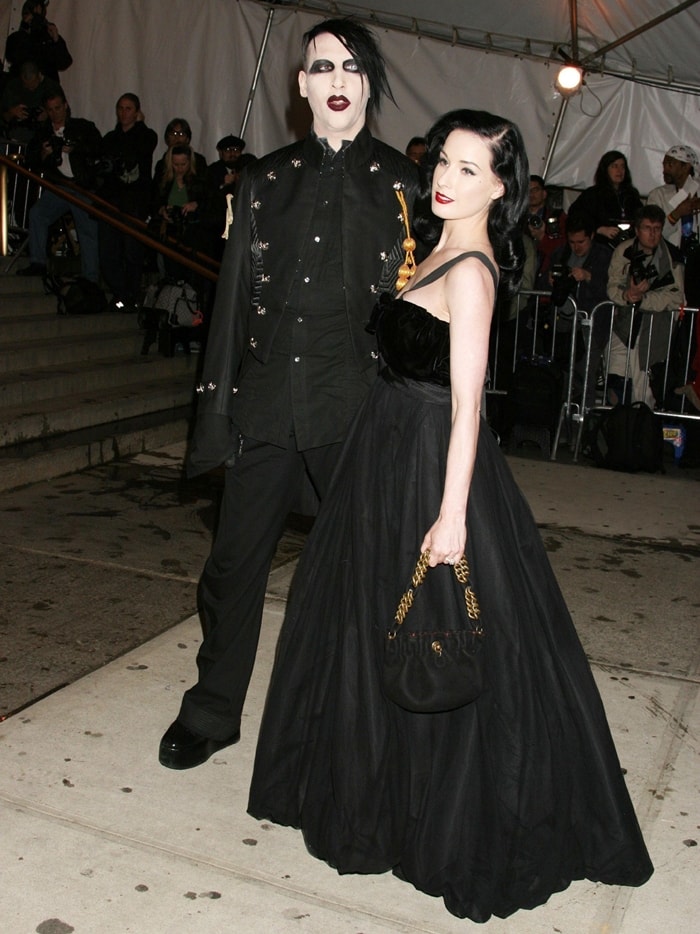 Marilyn Manson and Dita Von Teese embrace dark glamour at The Costume Institute's Gala Celebrating "Chanel," with Manson in an embellished black ensemble and Dita stunning in a dramatic velvet-accented ball gown at The Metropolitan Museum of Art in New York City