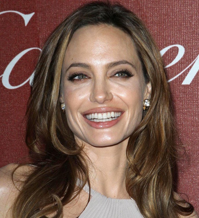 Angelina Jolie glows with soft glam makeup and loose waves, letting her neutral-toned gown and understated elegance take center stage at the Palm Springs International Film Festival