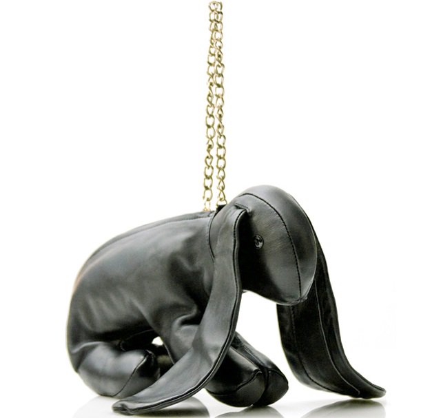 The Ginny bag is shaped like a rabbit, complete with floppy ears, button eyes, and little feet, crafted primarily from black leather with a suede lining for a luxe interior feel