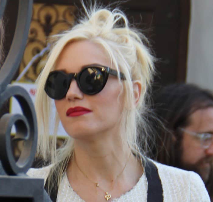 Gwen Stefani pairs her edgy updo with bold red lips and chic Cutler Gross 0734 keyhole sunglasses