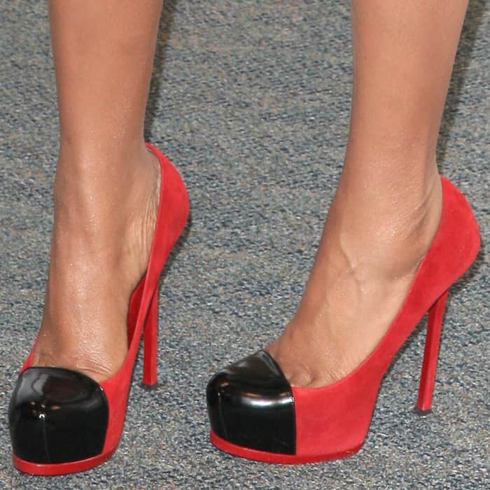A close-up of Jennifer Hudson’s Yves Saint Laurent “Tribtoo” pumps highlights the style’s signature hidden platform, rounded almond toe, and glossy black patent cap-toe contrasted against vivid red suede