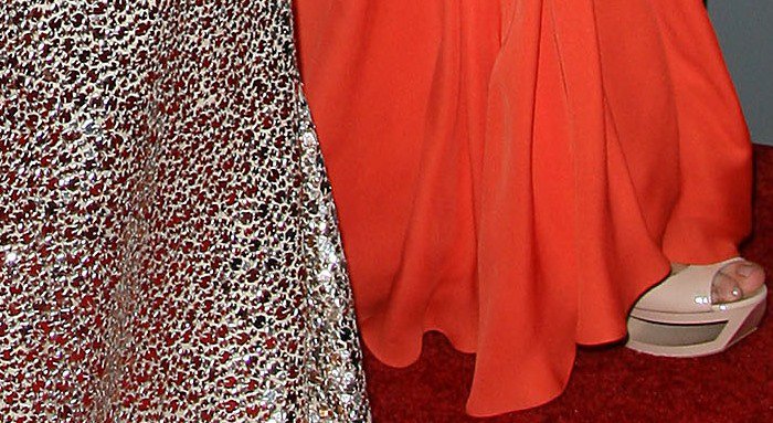 Kelly Osbourne’s pale pink Casadei platform sandals peek out beneath her flowing Honor gown, revealing the shoes’ hollowed platforms and towering sculptural heels