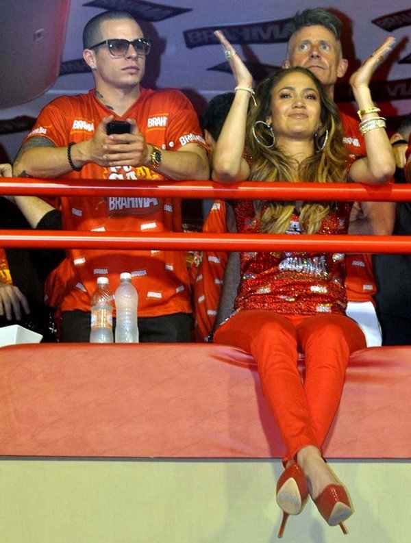 Jennifer Lopez exudes vibrant glamour in an all-red look — sparkling sequin top, matching pants, and red Casadei python pumps — as she cheers from the stands at Rio de Janeiro’s Carnival parade on February 19, 2012