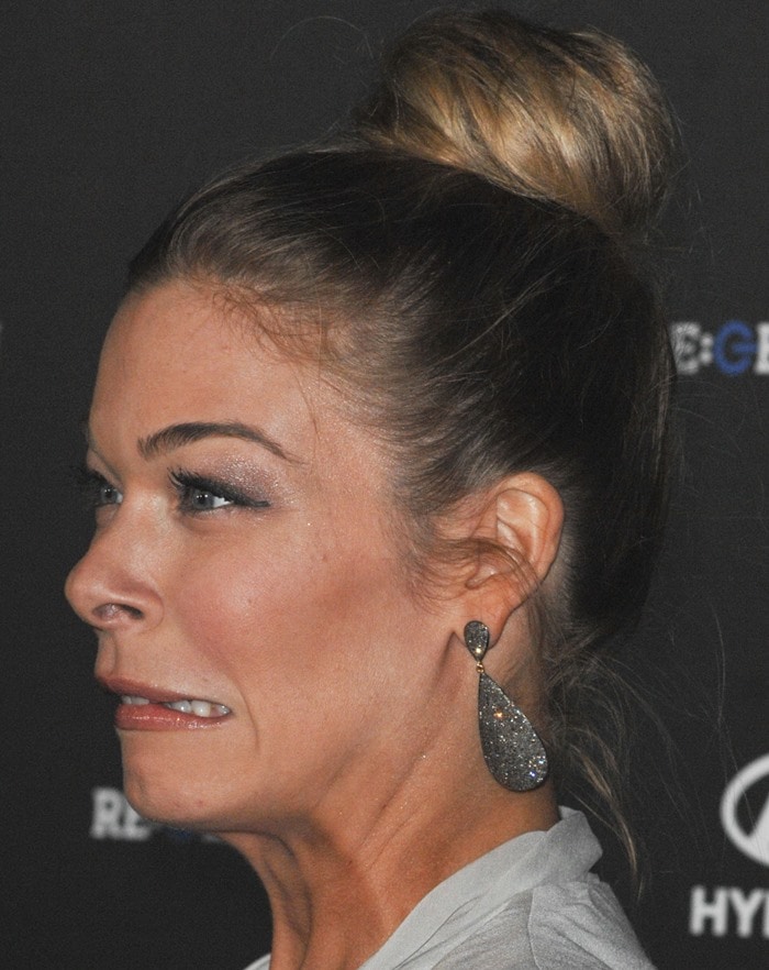 LeAnn Rimes pulls a funny face on the red carpet, showcasing her glamorous updo and sparkling teardrop earrings at the event