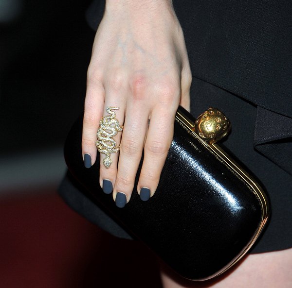 Lily Collins toting a gold and black Alexander McQueen clutch
