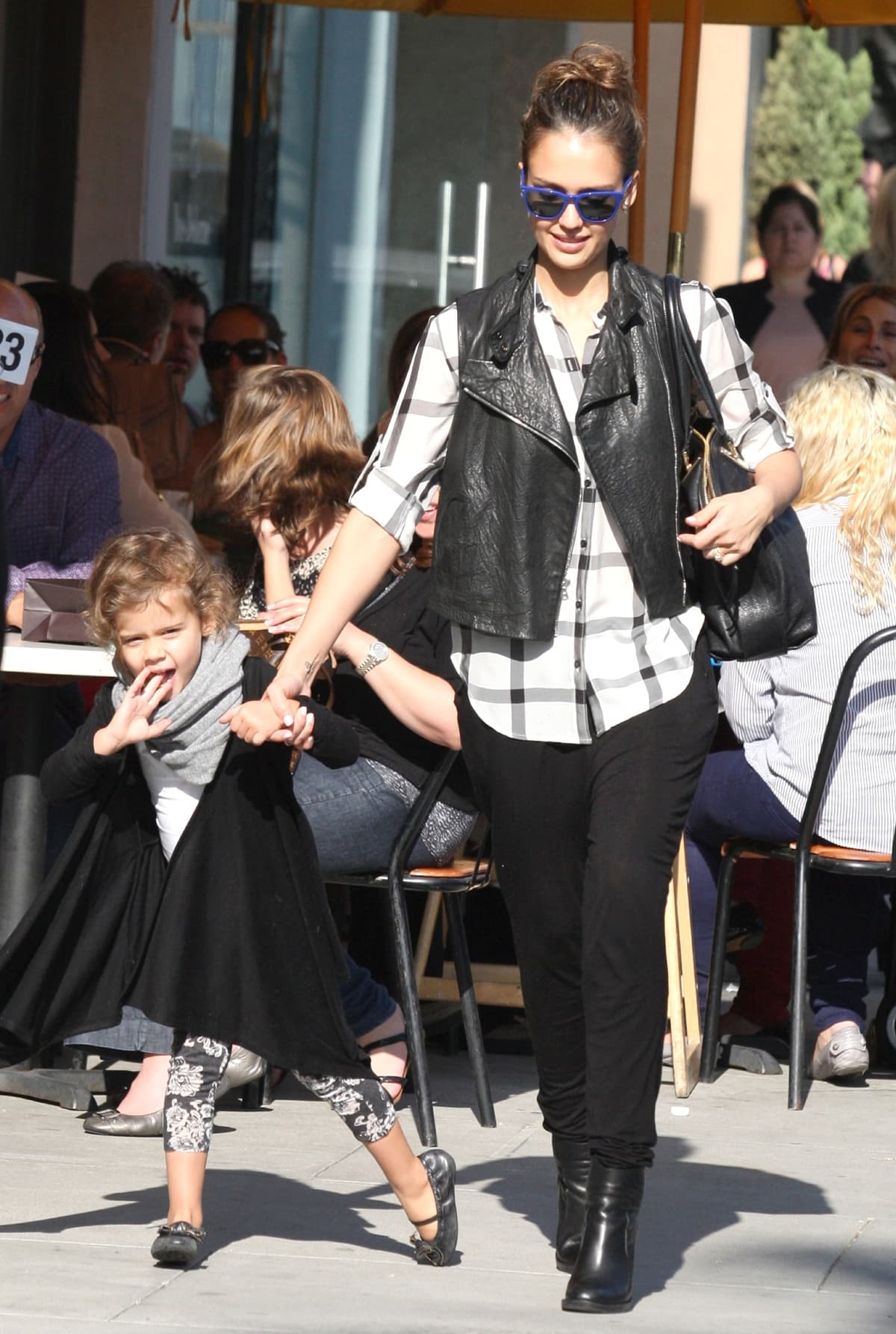Jessica Alba steps out in Los Angeles wearing a plaid Madewell silk shirt layered under a black leather vest, paired with skinny black pants, sleek ankle boots, and a large Chloé Angie bag for a polished take on casual street style