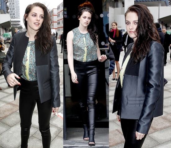Kristen Stewart in Balenciaga glove sandals Kristen Stewart wore a floral sleeveless shell top under a collarless black satin blazer and skintight black leather pants that melded into her black open toe sandal booties