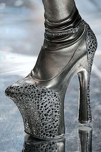 Alexander McQueen Fall 2009 RTW shoes A closer look at Alexander McQueen’s Fall 2009 runway boots reveals the collection’s signature fusion of sculptural height and intricate texture, with towering platforms and embossed finishes that elevate the design into wearable art