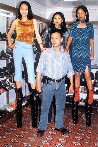 James Syiemiong 20-inch heels Indian designer James Syiemiong stands alongside models balancing in his record-breaking 20-inch platform boots, a striking demonstration of just how extreme—and wearable—these towering creations are
