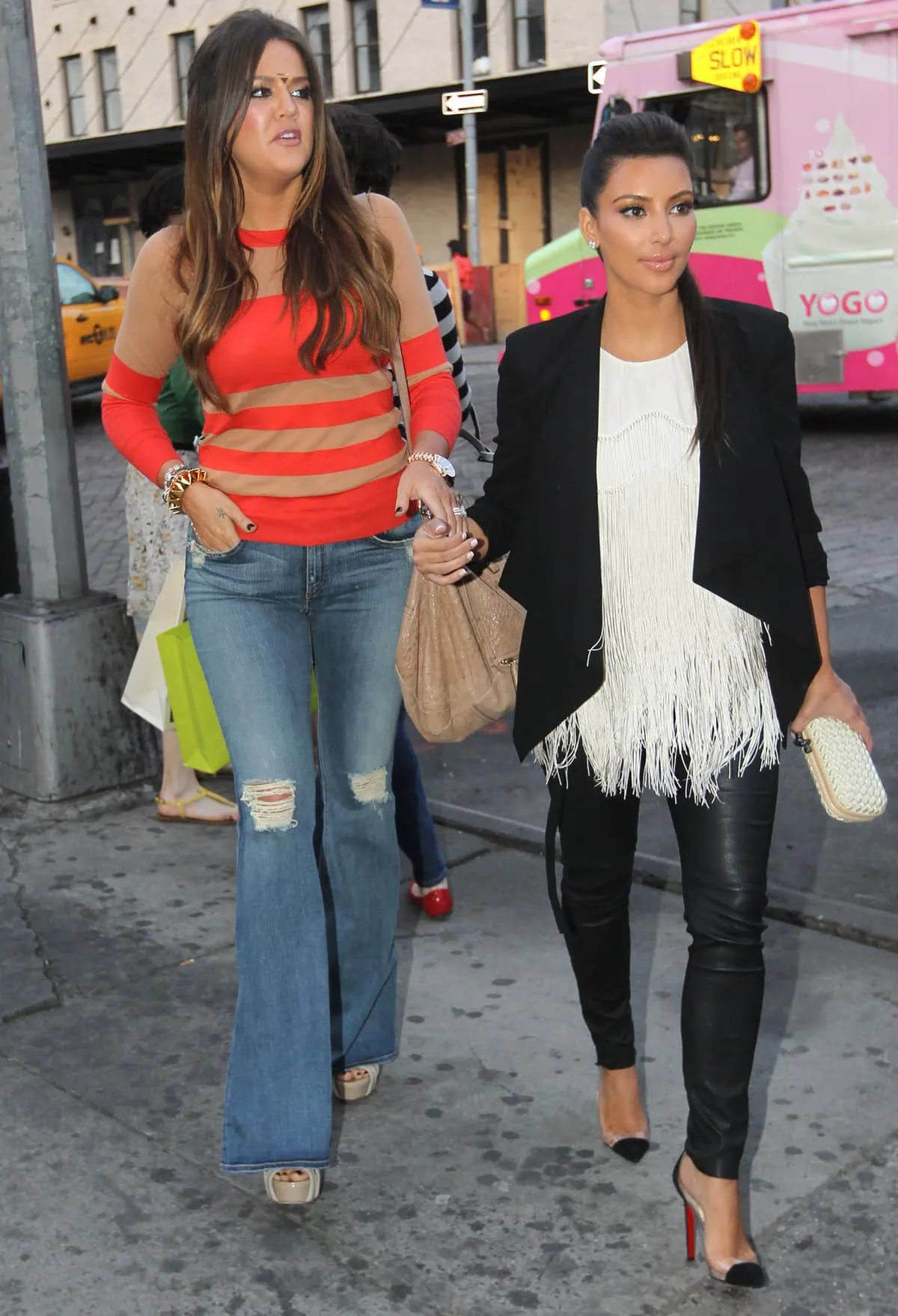 Khloé Kardashian steps out with Kim in New York City on April 22, 2012, styling a gold bindi, layered striped knitwear, flared jeans, and leg-lengthening wedge sandals that subtly elevate her boho-chic silhouette