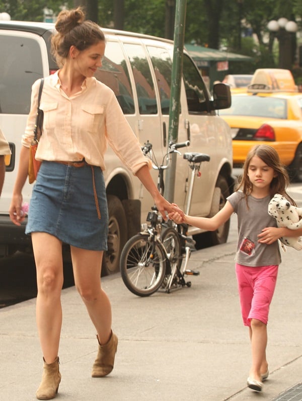 Katie Holmes strolls through Union Square, NYC, with daughter Suri Cruise on May 30, 2012, showcasing casual-chic style in suede ankle boots and a denim mini skirt