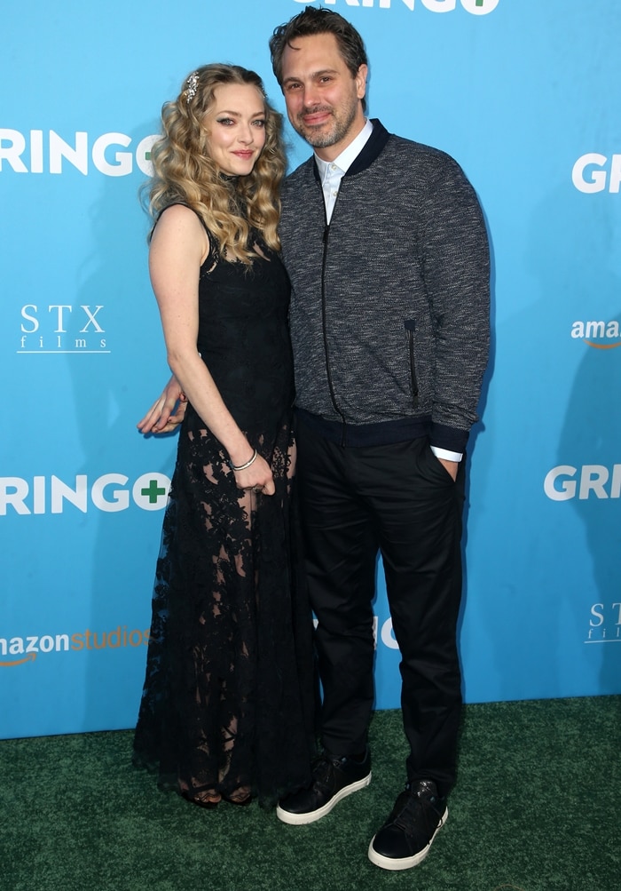 Actress Amanda Seyfried stepped out in a sleek black lace gown paired with strappy Giuseppe Zanotti heels, joined by husband Thomas Sadoski in a relaxed tailored look at the Gringo world premiere in Los Angeles on March 6, 2018