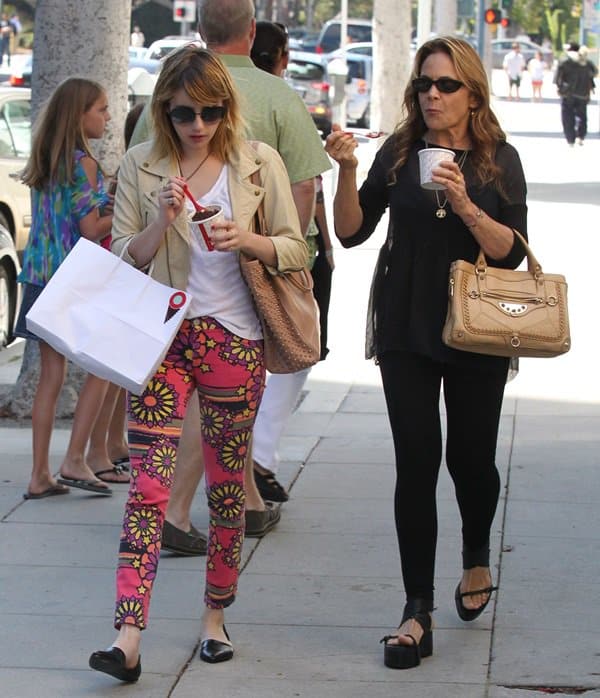 Emma Roberts keeps it playful in floral-print pants and Jenni Kayne flats, while her mom, Kelly Cunningham, opts for sleek all-black with platform sandals and a tan leather tote during their Los Angeles ice cream outing