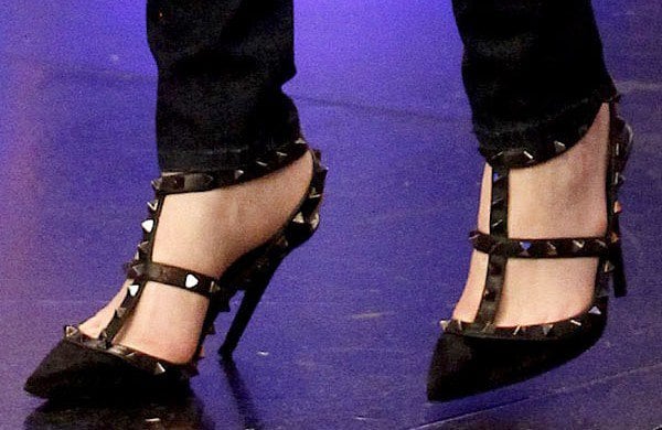 Emma Stone’s feet in black Valentino Rockstud T-strap pumps featuring patent leather and signature pyramid studs