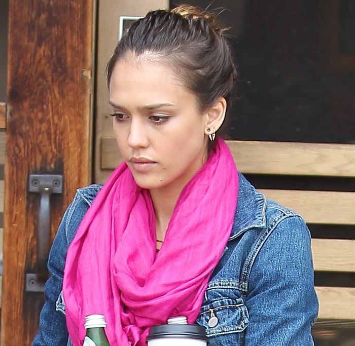 Jessica Alba wears a bright pink scarf with a denim jacket while carrying coffee and bottled drinks outside a café