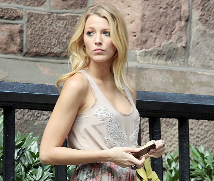 Blake Lively wears her hair in loose, tousled waves and stuns in a beaded tank top while holding a clutch