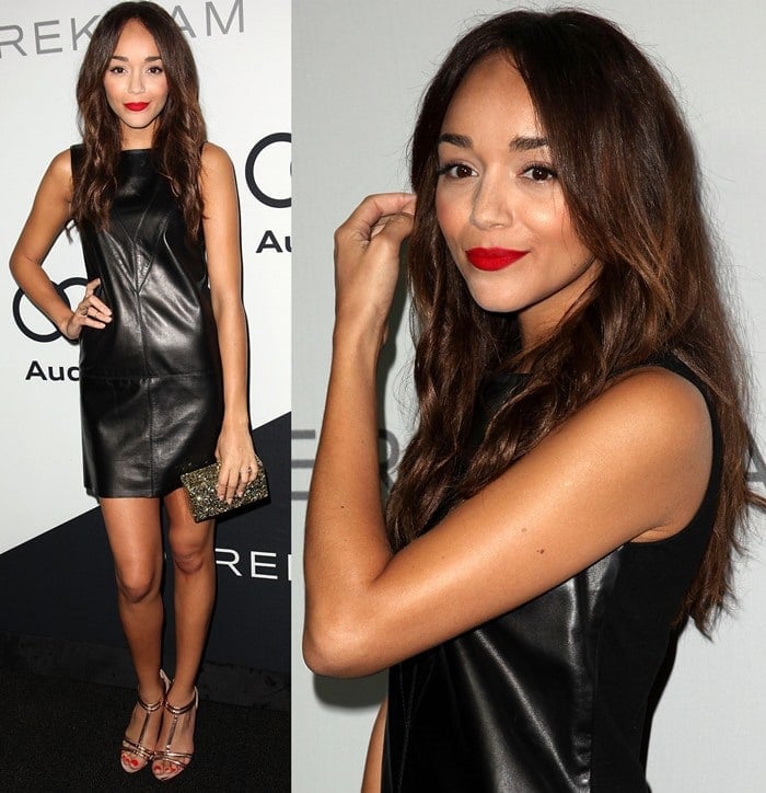 Ashley Madekwe exudes sleek sophistication in a black leather mini dress paired with metallic strappy heels, a sparkling clutch, and a bold red lip for a statement-making look