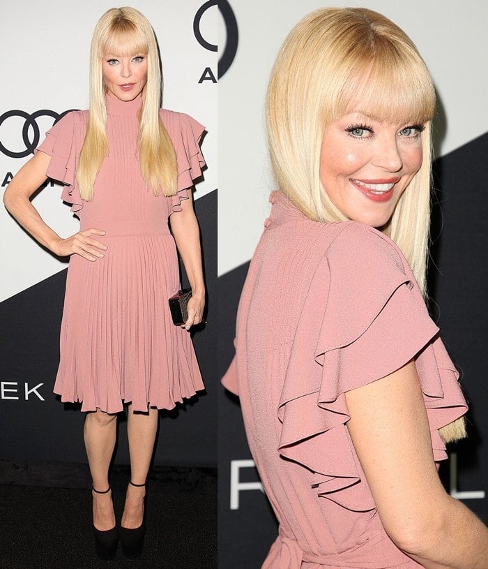 In a soft blush pink pleated dress with flutter sleeves paired with black platform heels, Charlotte Ross embraces timeless elegance and feminine charm
