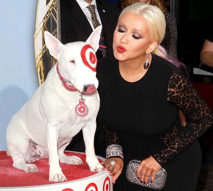 Christina Aguilera playfully puckers up beside Target mascot Bullseye at the 2012 NCLR ALMA Awards in Pasadena, accessorizing her black Michael Kors gown with sparkling jewelry and a crystal-covered box clutch
