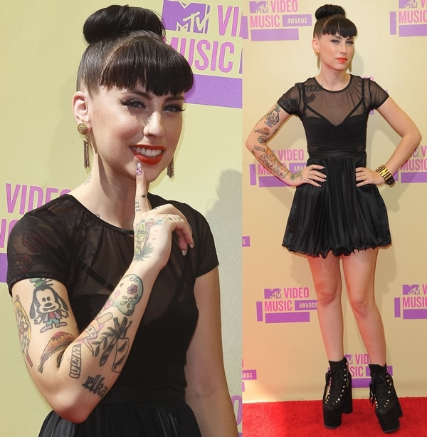 Kreayshawn steps onto the MTV Video Music Awards red carpet in a sheer black mini dress, balancing playful attitude with edgy tattoos and a sculptural updo
