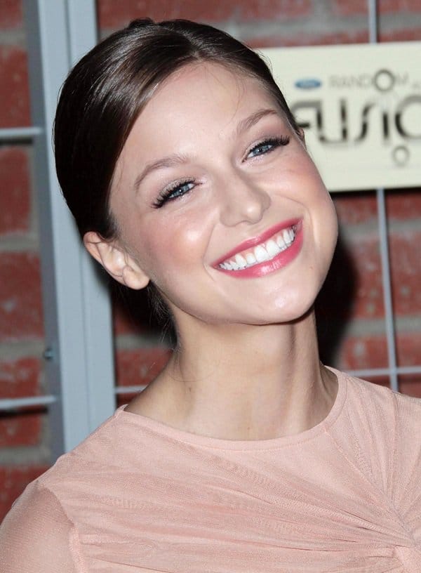 Melissa Benoist shows off her sparkling blue eyes and elegant updo hairstyle, perfectly complementing her soft makeup and blush-toned dress