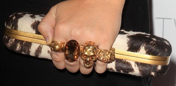 Statement Accessory: Rebel Wilson completes her ensemble with the iconic Alexander McQueen knuckle-duster clutch, adding a bold and luxurious touch