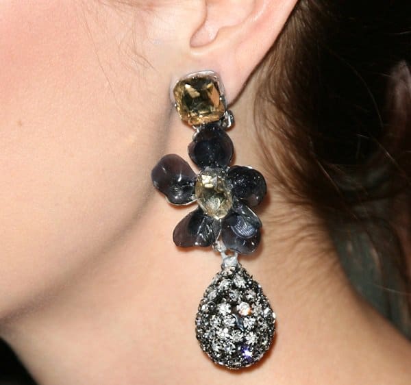 Eva Amurri shows off her oversized floral statement earrings, featuring gem-studded petals and a sparkling teardrop accent that added drama to her minimalist LBD look