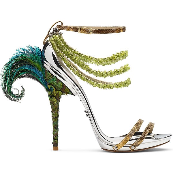 Gianluca Tamburini Amazon Gianluca Tamburini’s Amazon sandal features cascading green crystal strands, gold leather straps, and a dramatic peacock-feather heel—channeling wild elegance with engineered precision