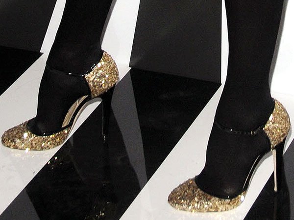 Kelly Bensimon dazzled in black stockings and glittering gold heels from Jimmy Choo, adding a glamorous touch to her ensemble with their sparkling finish