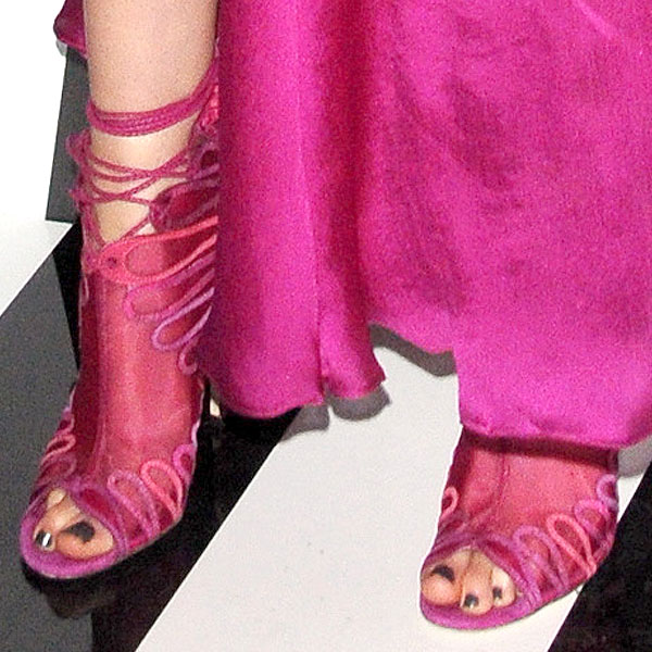 Krysten Ritter's feet look stunning in Jimmy Choo 'Kairo' heels, featuring intricate pink lace-up detailing that perfectly complements her dark pedicure