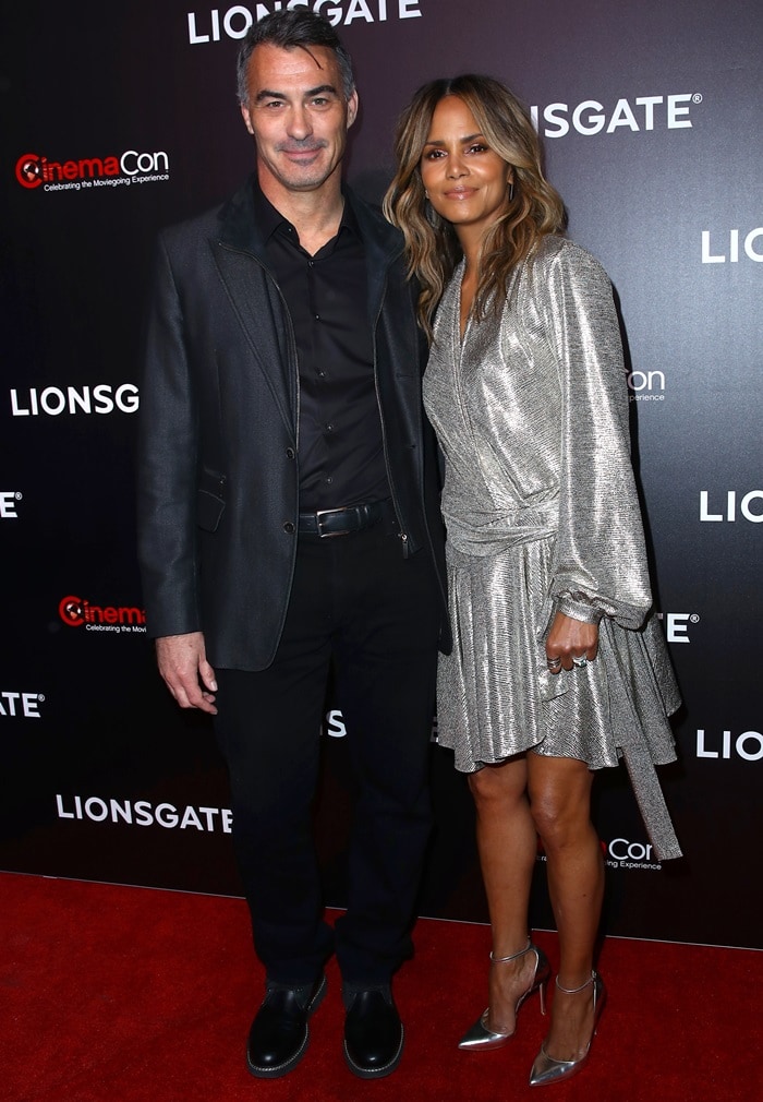 Halle Berry poses alongside John Wick director Chad Stahelski at CinemaCon 2019, where his 6ft 1 frame visibly towers over her 5ft 5 stature despite her pointed-toe metallic heels