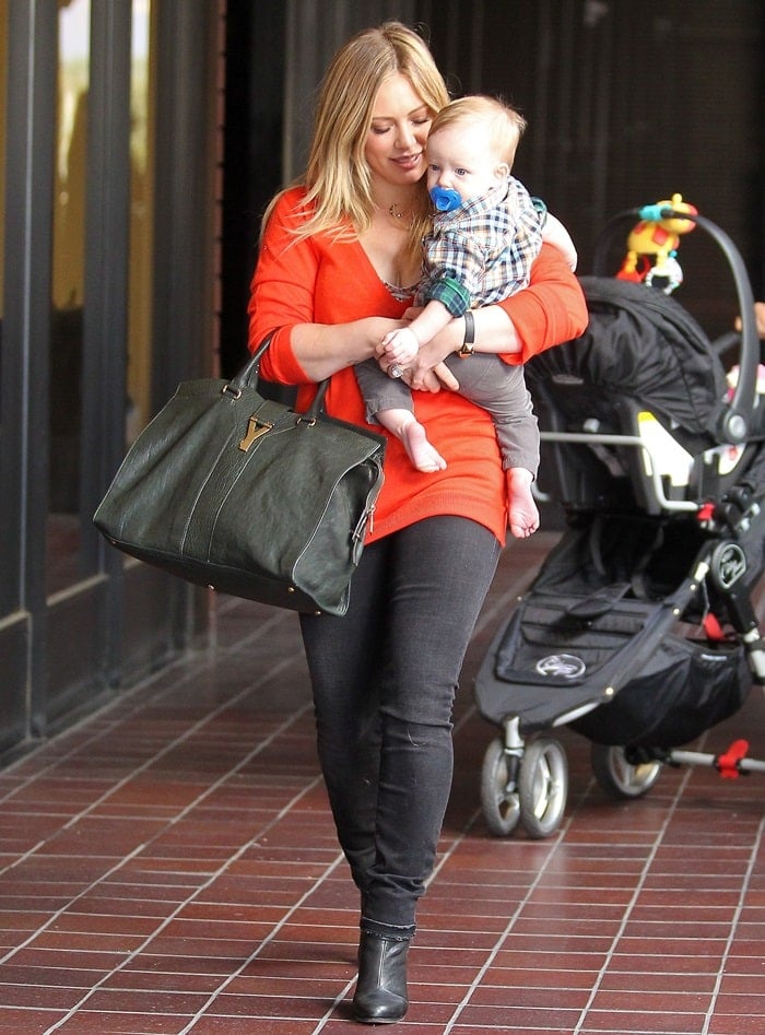Hilary Duff was spotted out in Sherman Oaks with her son Luca on November 28, 2012, wearing a Yves Saint Laurent East West bag and Rag Bone Harrow strappy ankle booties in black